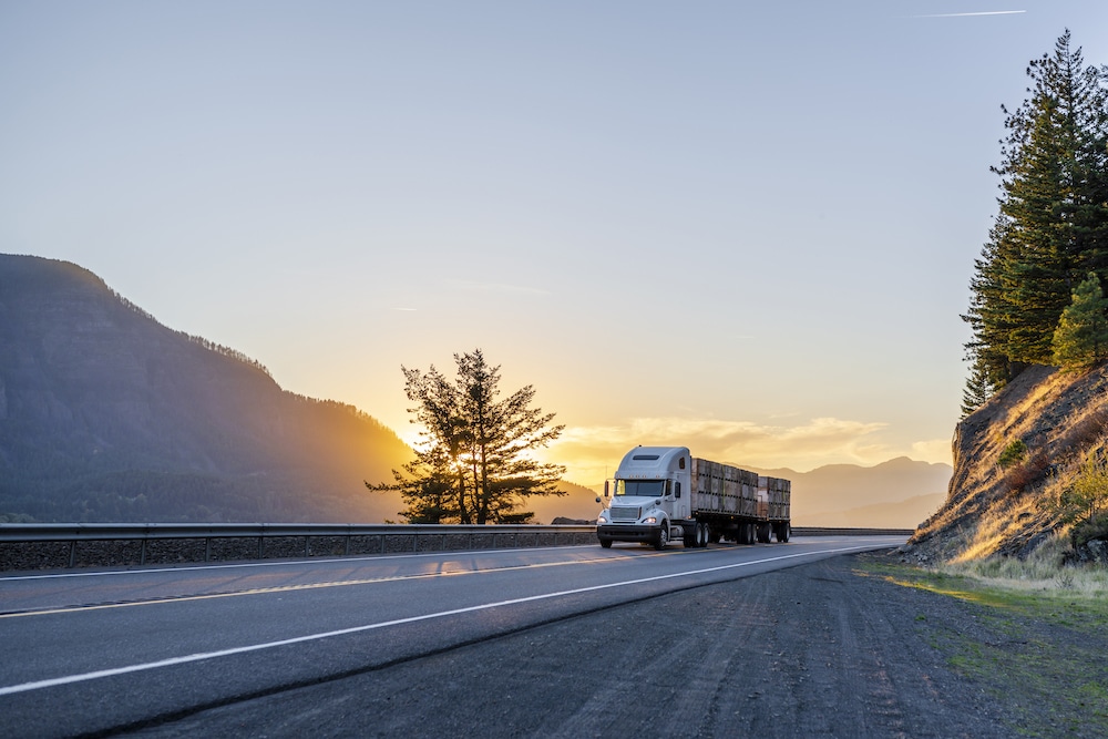 Semi truck driving along the highway in the mountains